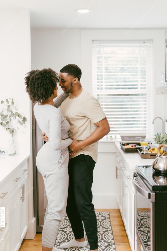 Black couple dancing in kitchen at home, intimate moment