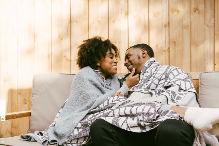 Couple snuggled under blankets, cozy and warm