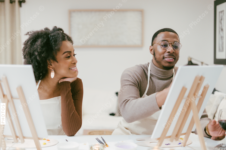 African American couple enjoys at home painting and craft date night, DIY