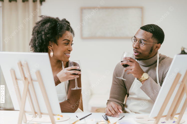 Couple having drinks during painting date night at home, DIY