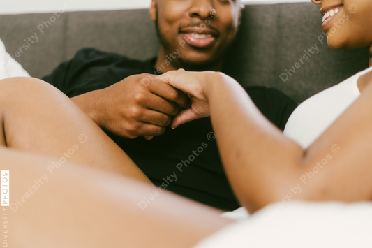 Black couple relaxing on bed at home, love connection