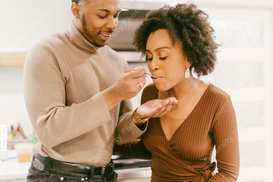 Black man feeds girlfriend dinner, intimate moment