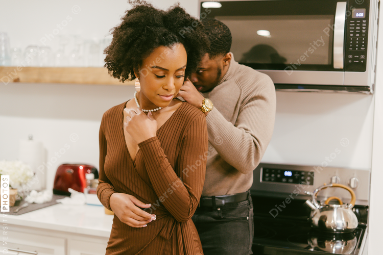 Black man puts anniversary gift necklace on girlfriend