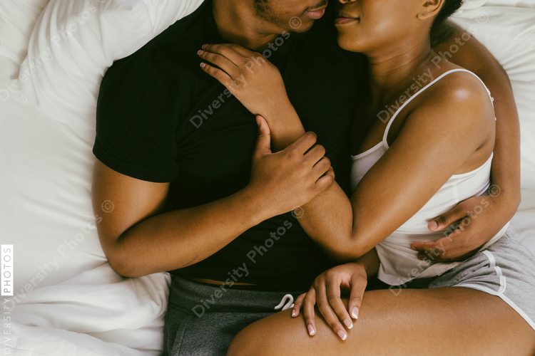 Young couple relaxing on bed at home, African American boyfriend and girlfriend love connection