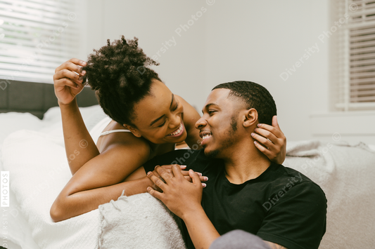 Beautiful Black couple embrace in bed at home, young love