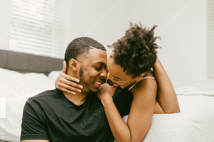 Beautiful Black couple embrace in bed at home, young love