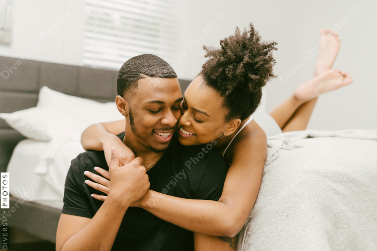 Beautiful Black couple embrace in bed at home, young love
