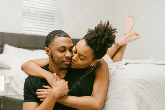 Beautiful Black couple embrace in bed at home, young love