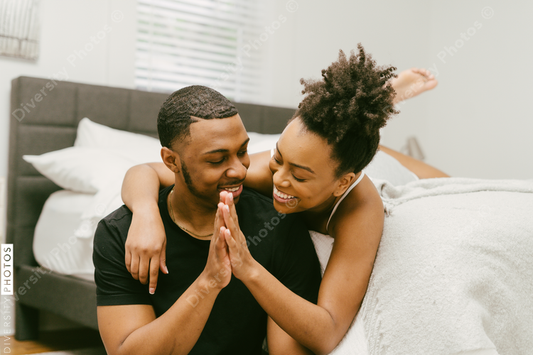 Black love, couple embracing on bed at home