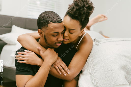 Black love, couple embracing on bed at home