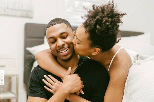 Black love, couple embracing on bed at home