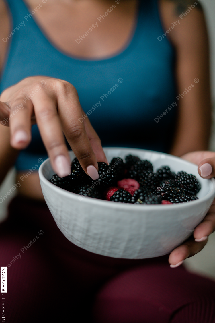 Black woman eating healthy fruit and berries