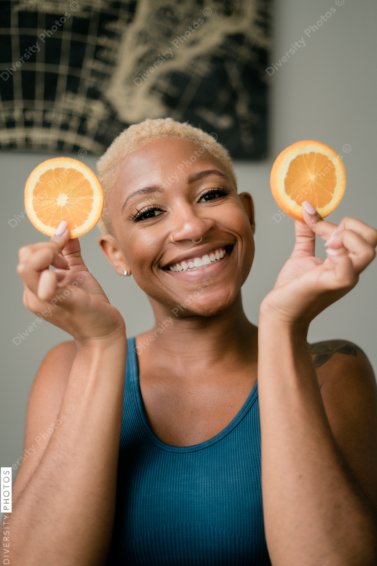 Happy and healthy young woman holding orange slices