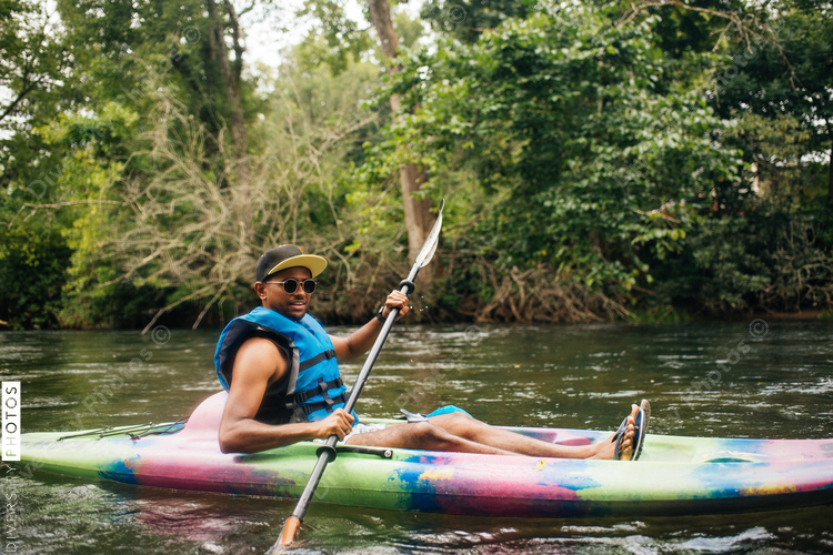 Man in sunglasses kayaking on river