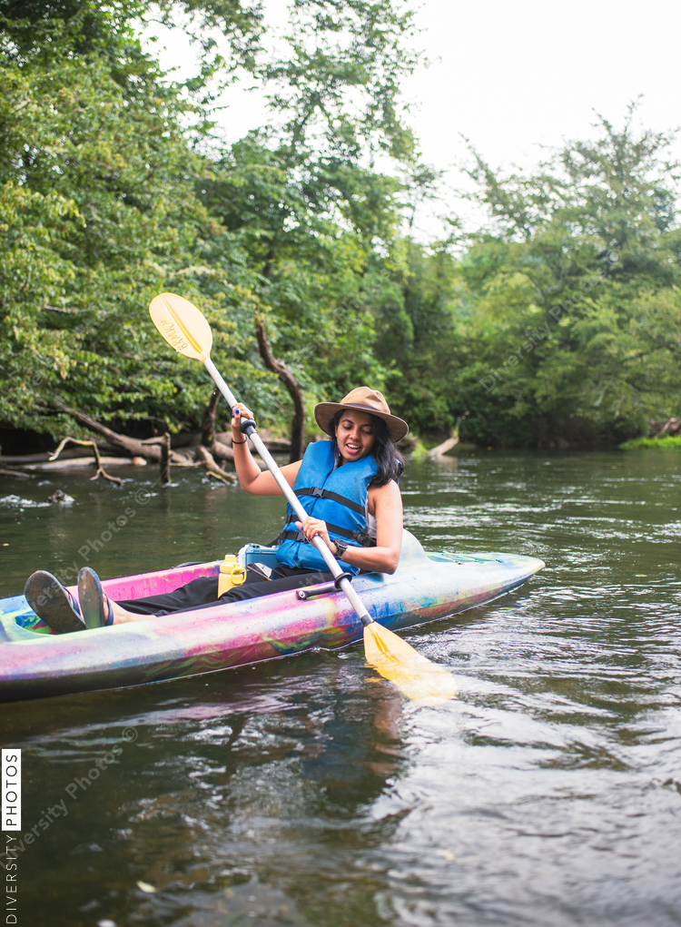 Smiling woman kayaking on river