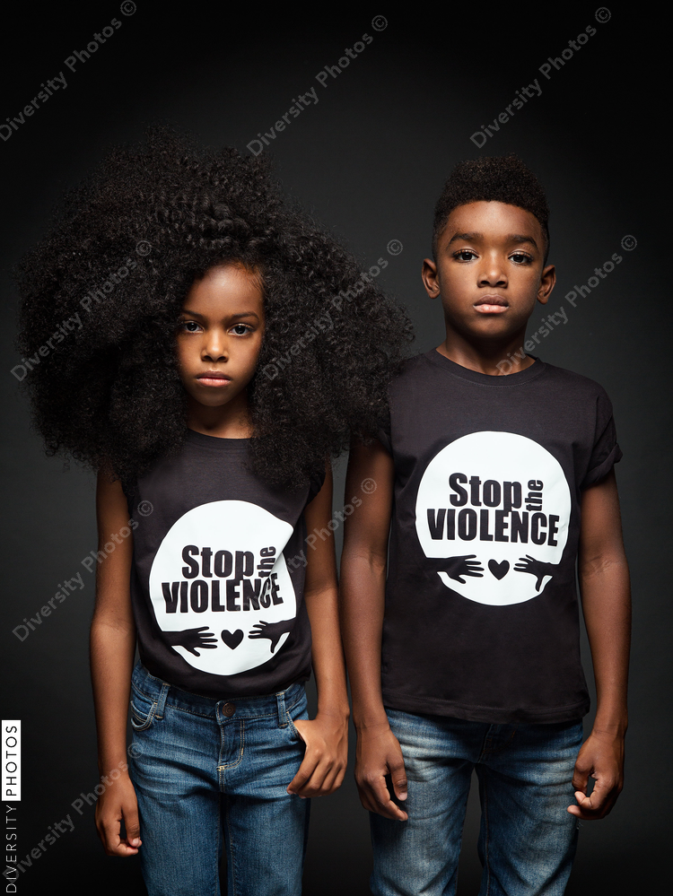 Portrait of children standing against black background