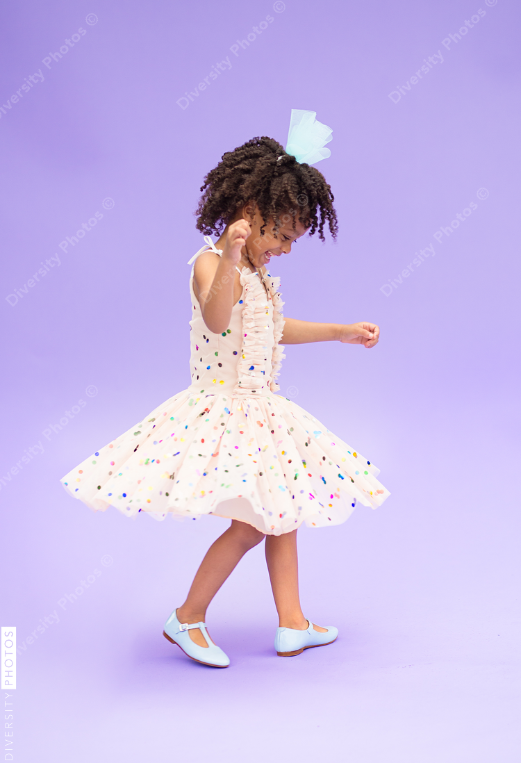 Side view of girl playing against purple background