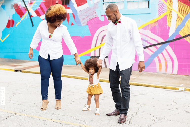 Happy parents holding daughters hand while walking outdoors