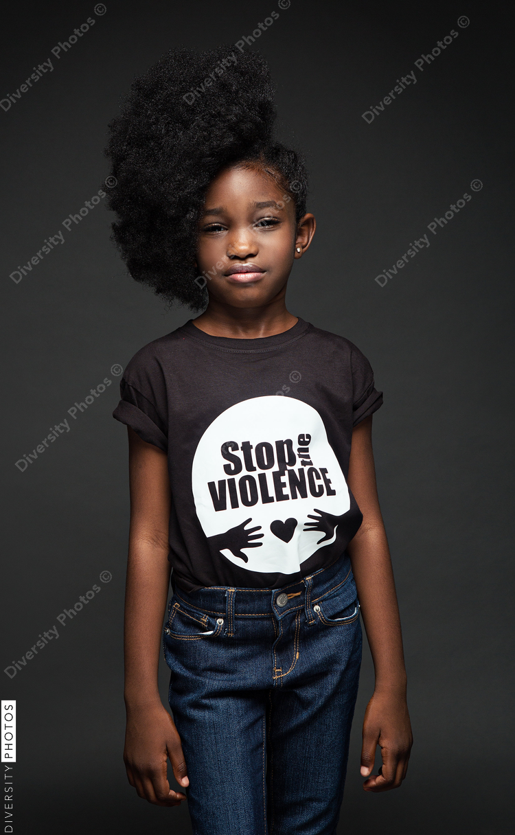 Portrait of girl standing against black background