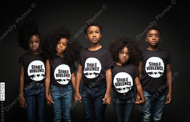 Portrait of children standing against black background