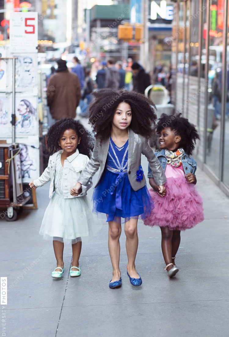Three little girls holding hands and wearing tutus