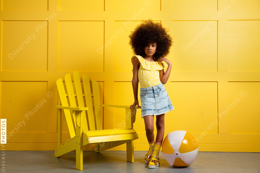 Young girl poses in yellow themed setting