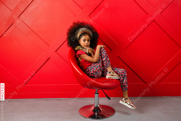 Young girl poses in red themed setting