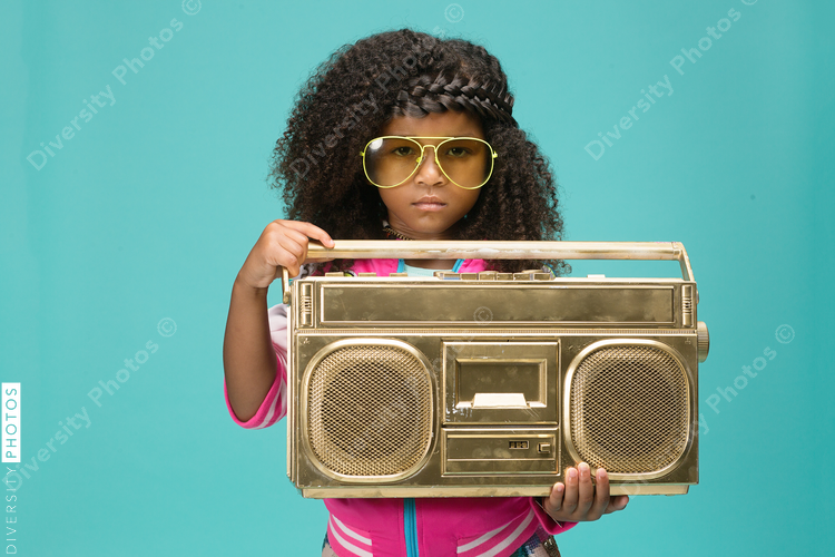 Girl wearing sunglasses and holding gold boombox