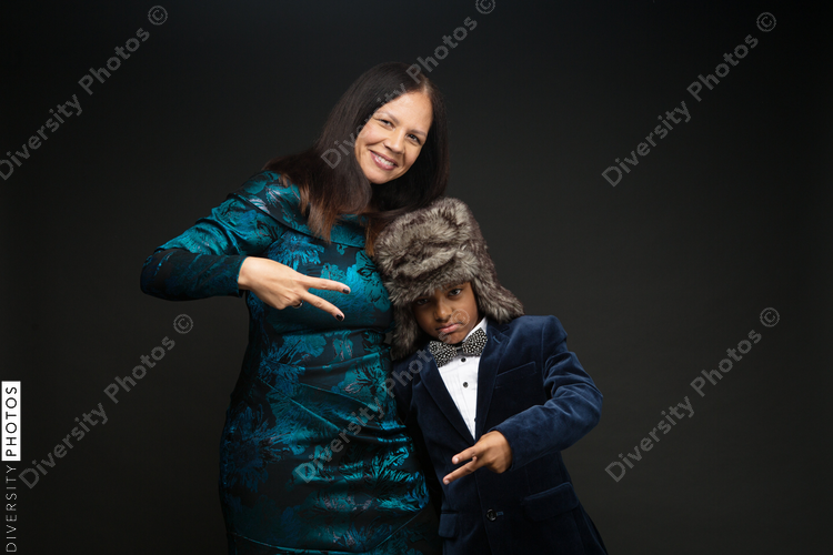 Mom and son showing peace sign against black background