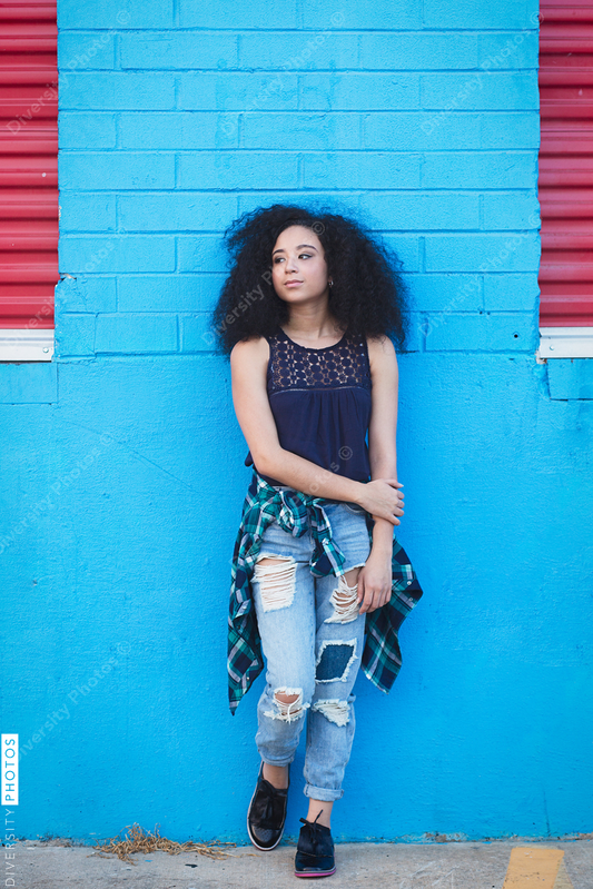 Young woman posing against wall