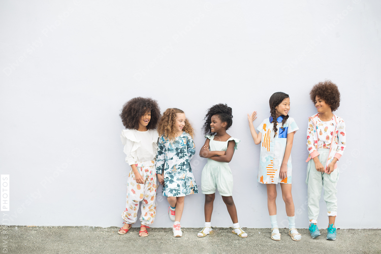 Children standing against white wall