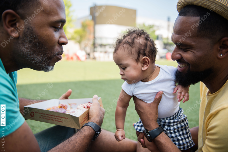 Baby looking at sweets in the hands of father