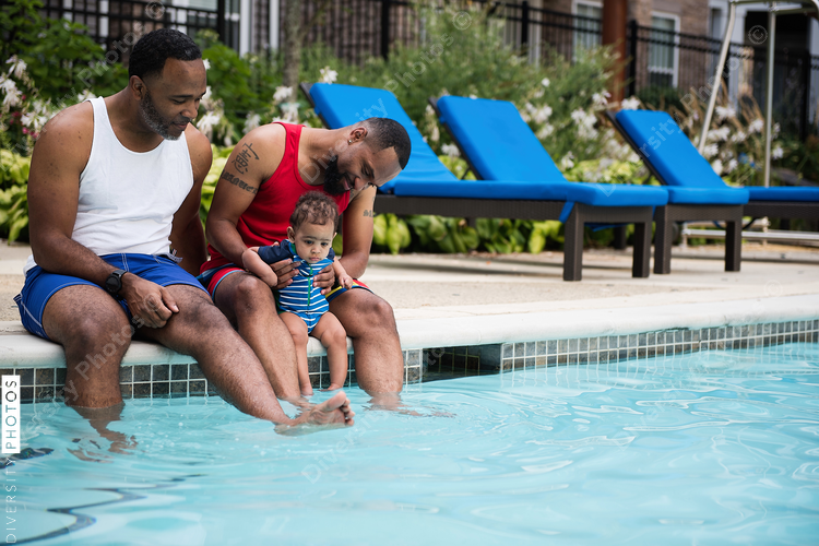 Man playing with water while baby is watching