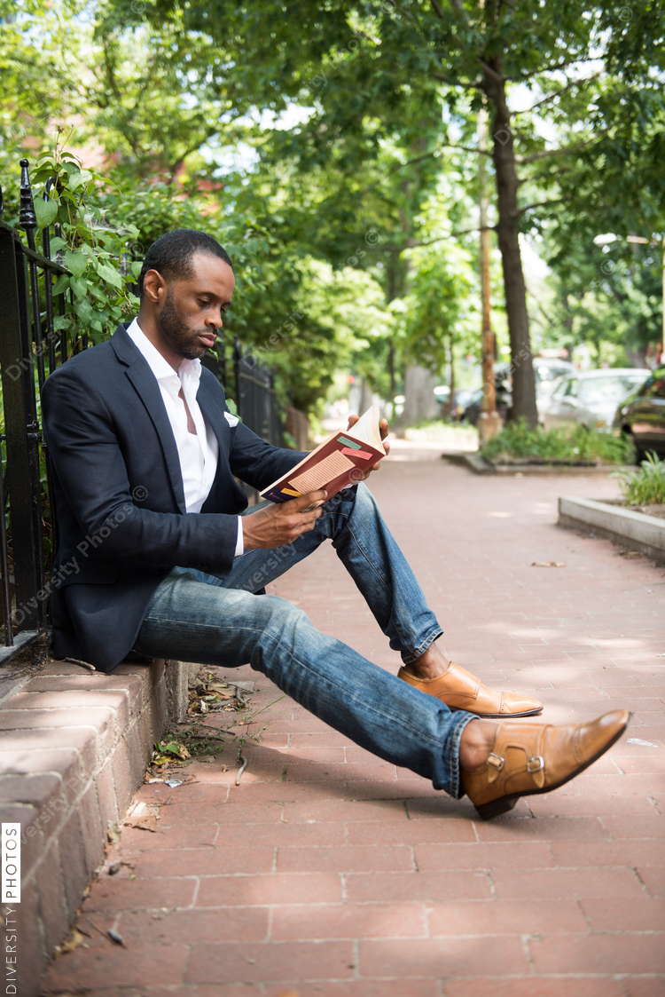 Businessman reading book while sitting outdoors