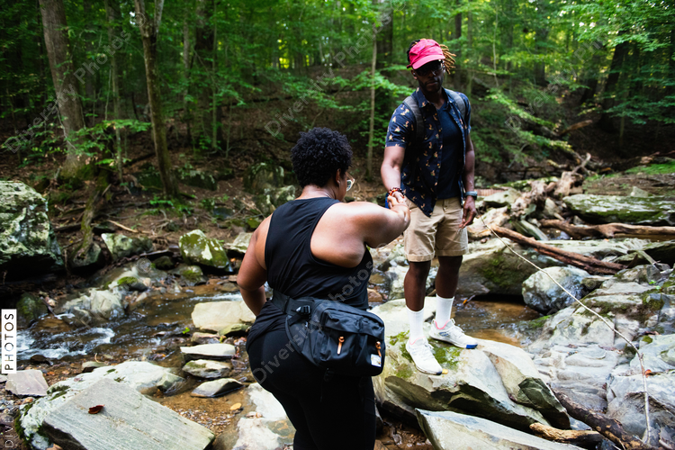Man helps woman on nature trail