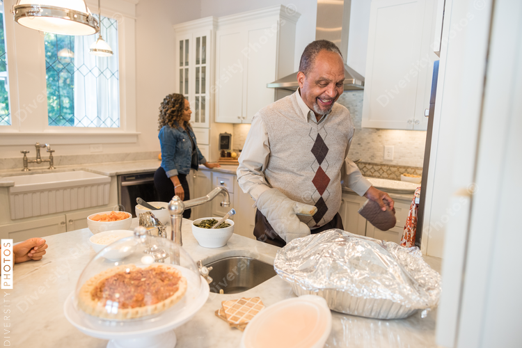 Black granddad preparing turkey for Thanksgiving dinner