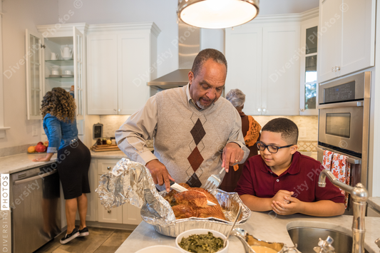 Black granddad preparing turkey for Thanksgiving dinner