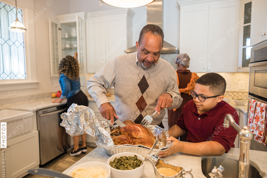 Black granddad preparing turkey for Thanksgiving dinner