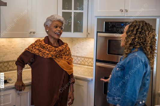 Black mother and daughter talking in kitchen
