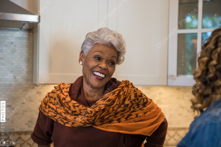 Black mother and daughter talking in kitchen