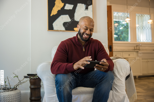 Black man watching sports on smartphone before thanksgiving dinner