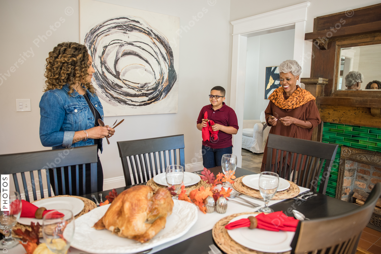 Family setting Thanksgiving dinner table