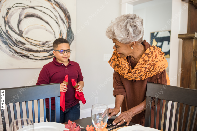 Grandmother and grandson doing Thanksgiving dinner setting
