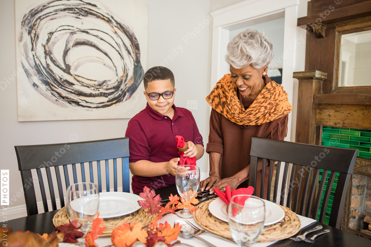 Grandmother and grandson doing Thanksgiving dinner setting