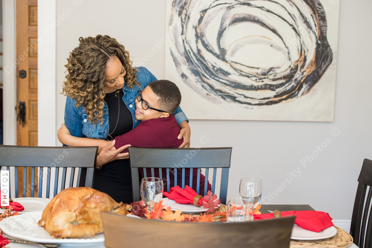 Black son helps mother do holiday table setting