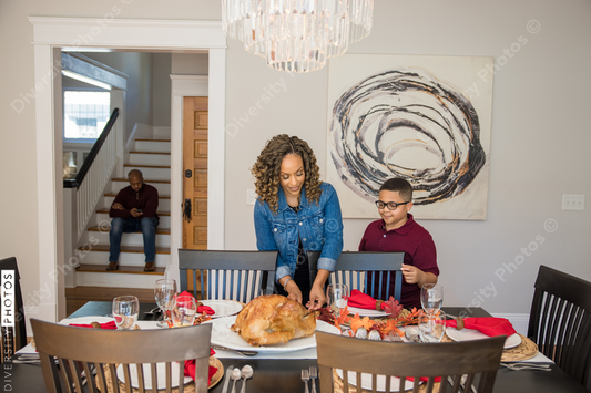 Black son helps mother do holiday table setting