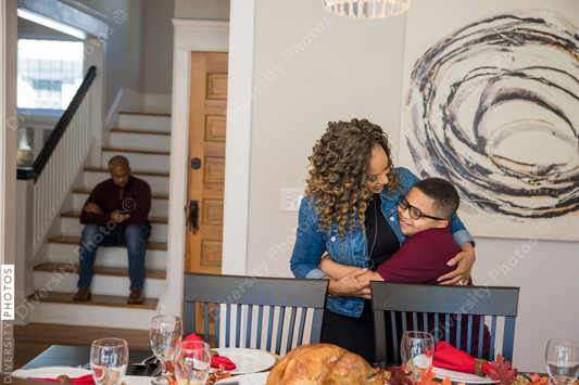 Black son helps mother do holiday table setting