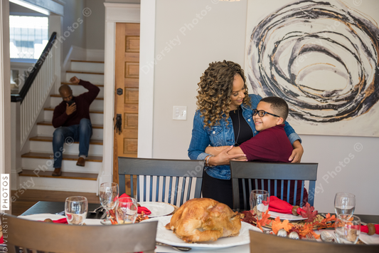 Black son helps mother do holiday table setting