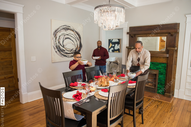 Black multigenerational men setting table for Thanksgiving  holiday meal
