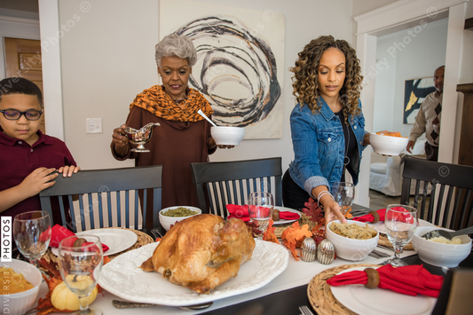 Black multigenerational family setting table for Thanksgiving  holiday meal